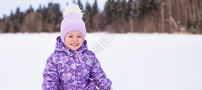 可爱的小可爱女孩 享受寒冬 阳光明媚的日子快乐围巾降雪天气孩子闲暇乐趣压痛女儿紫色图片