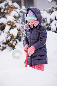 小女孩在冬天天玩雪铲雪的游戏微笑幸福婴儿雪堆童年女性孩子快乐雪花毛皮图片
