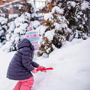 可爱的小女孩玩雪铲雪 在冬日打滚雪堆孩子女性童年快乐微笑闲暇婴儿公园雪花图片