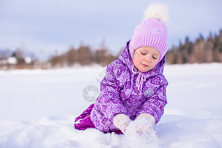 快乐的小女孩在寒冬阳光明日玩雪童年草地活动幸福女儿女孩围巾降雪森林乐趣图片