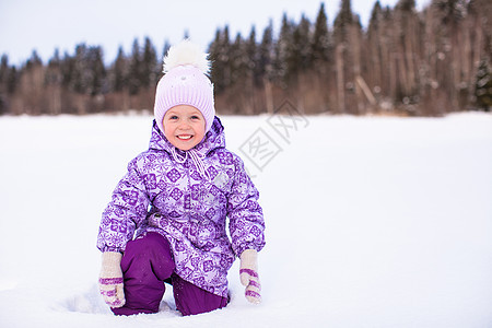快乐可爱的小可爱女孩 在寒冬阳光明日的雪上玩得开心幸福压痛享受童年紫色乐趣假期婴儿情绪闲暇图片