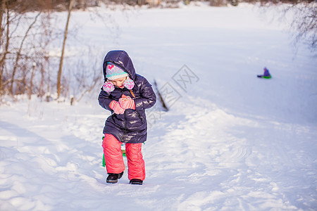 小可爱的快乐女孩 享受阳光明媚的冬日雪草地婴儿幸福微笑乐趣森林帽子喜悦公园眼睛图片