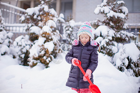 小女孩在冬天天玩雪铲雪的游戏童年公园雪花微笑季节幸福森林雪堆快乐孩子图片