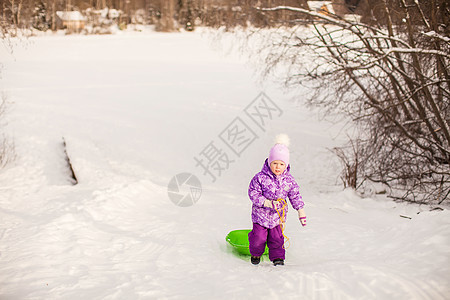 小女孩在温暖的冬日拉起雪橇眼睛微笑帽子草地雪花幸福季节女儿喜悦乐趣图片