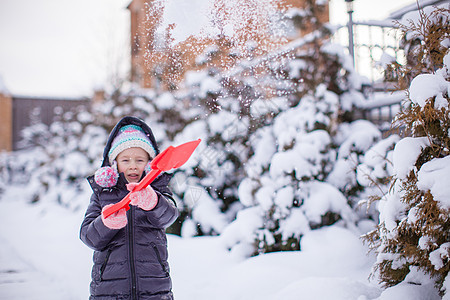 小女孩在花园里玩红铲子的小姑娘晴天微笑童年闲暇孩子女性公园手套季节森林图片