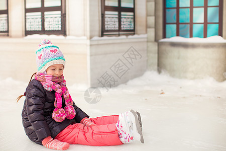 秋天后 可爱的小女孩坐在冰上 穿着溜冰鞋坐着冰雪冰鞋滑冰场运动教学锻炼爱好喜悦活动女性溜冰场图片