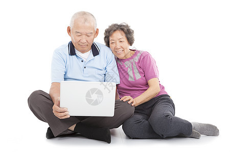 快乐的老年情侣观看或依靠笔记本电脑图片