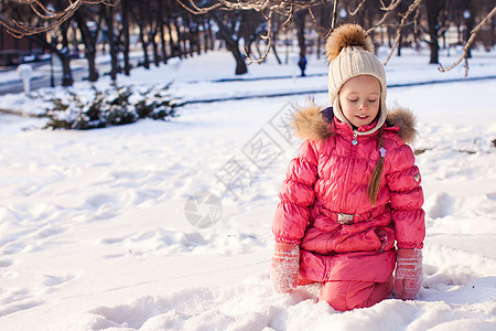 可爱的小女孩 在寒冬天户外玩得开心雪堆公园雪花微笑森林婴儿毛皮手套孩子闲暇图片