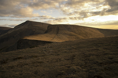 秋天在山上傍晚草地弹簧远足游客人行道太阳滑雪岩石日落顶峰图片
