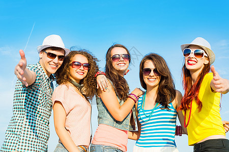 身戴太阳眼镜和帽子的青年群体女孩太阳乐趣派对夫妻活力友谊蓝色精力拥抱图片