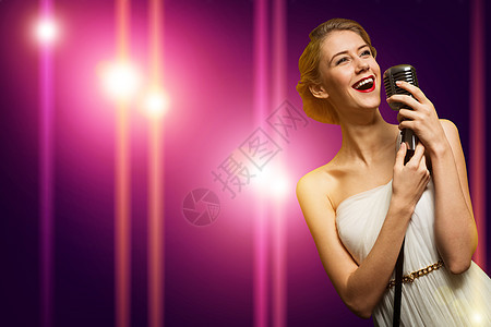 具有麦克风的有吸引力的女性歌手播音员俱乐部乐队卷曲星星演员戏剧性唱歌享受夜店图片