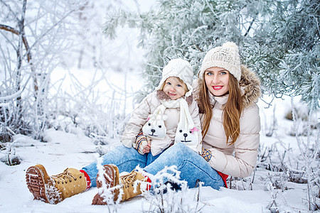 冬季森林中的母亲和女儿活动乐趣微笑童年孩子树木喜悦父母闲暇家庭图片