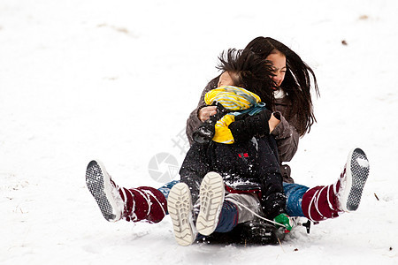 两个姊妹骑雪橇 紧紧抱在一起姐姐活力孩子下坡运动乐趣速度闲暇笑声照顾图片