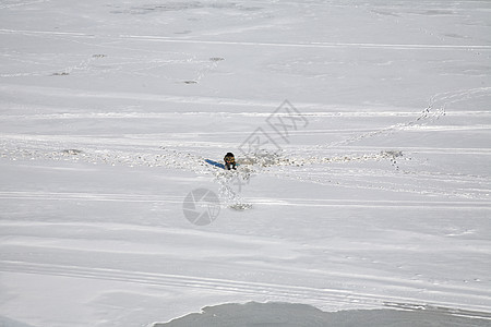 冬天在冰冻河边的渔民图片