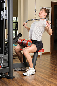 年轻人在健身房做拉特拉特拉下拉倒运动器材纬度男性运动员出汗男人权重杠铃机器肌肉图片
