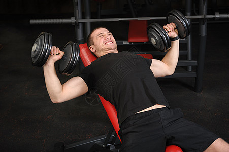 青年男子在健身房做邓宾贝尔加连座记者工作男人出汗哑铃运动倾斜胸部锻炼长椅男性肌肉图片