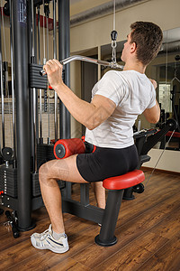 年轻人在健身房做拉特拉特拉下拉倒运动器材运动员机器训练肌肉杠铃纬度男人男性权重图片