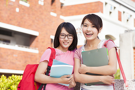 有两个在校园藏书的笑着学生学习女孩成人团体课堂晴天笔记本微笑建筑学校图片