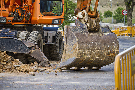 道路建设工程的近距离小型滑雪式驾驶式搬运车挖土机活动地面刀刃工作蓝色反铲装载机机械运动沙坑图片
