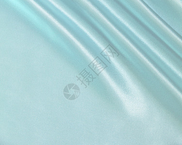 平滑优雅的蓝色丝绸作为背景银色织物布料曲线海浪材料纺织品投标折痕图片