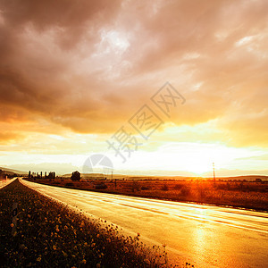 湿道路和天空日落风暴电缆天气阳光辉光水坑地平线太阳光线孤独图片