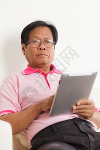 高级男子使用数字平板电脑男性人士学习老年人白色电子灰色头发退休成人图片