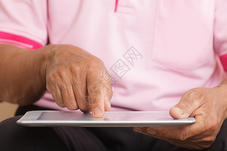 高级男子使用数字平板电脑老年人学习沙发软垫退休白色技术头发成人长椅图片