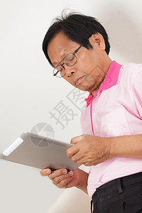 高级男子使用数字平板电脑男性学习男人电子老年人退休沙发软垫成人商务图片