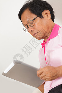 高级男子使用数字平板电脑成人房子退休学习男人长椅互联网老年人人士软垫图片