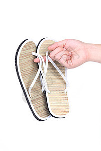 手握着一对带条纹的拖鞋衣服水平沙滩失败白色字拖工作室稻草假期鞋类图片