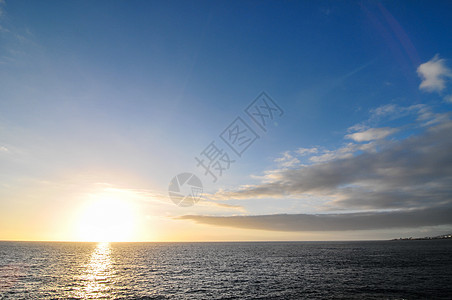 日落时的彩云气氛红色蓝色阳光太阳宗教戏剧性海滩多云精神图片