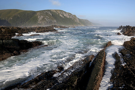 南非的沿海景点爬坡热带地平线阳光石头荒野悬崖海岸海浪天空图片