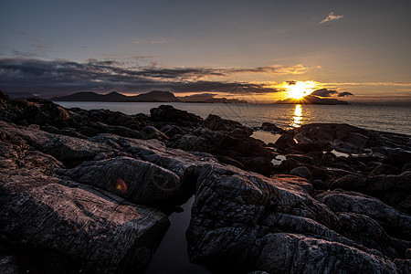 挪威海岸日落峡湾海洋岩石石头图片