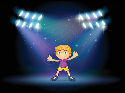 一个可爱的小男孩 跳舞在舞台中间的舞台上图片