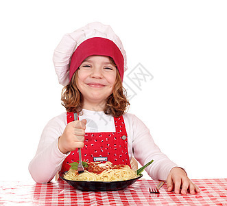 快乐的小女孩做饭吃意大利面乐趣青年帽子面条烹饪童年孩子们美食厨师食物图片