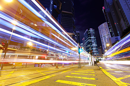 夜间在香港快速移动的车灯路口黑色城市建筑速度黄色公司景观踪迹红色背景图片