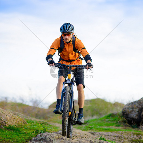 在美丽的山道上骑自行车的赛车女运动员冒险车轮岩石行动成人天空男生娱乐踪迹活动图片