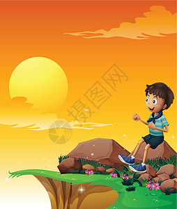 一个快乐的男孩坐在悬崖附近的大岩石上图片