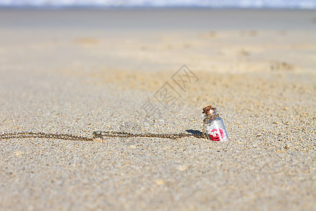 白沙滩上的小瓶小瓶子 在松绿海的背景之下热带海岸线玻璃晴天旅行明信片海滩生存支撑软木图片