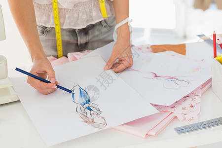 时装设计师在设计中工作的中间部分女性女士卷尺创造力作坊铅笔工作室裁缝专注商业图片
