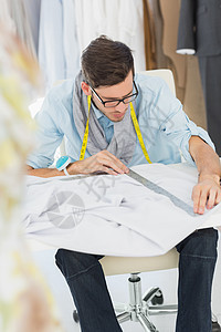 男性时装设计师在设计自己的设计男人工作室创造力商业裁缝作坊造型师绘画专注桌子图片