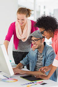 在办公室做电脑工作的笑脸艺术家便服男人快乐技术键盘团队女性设计师色轮职场图片