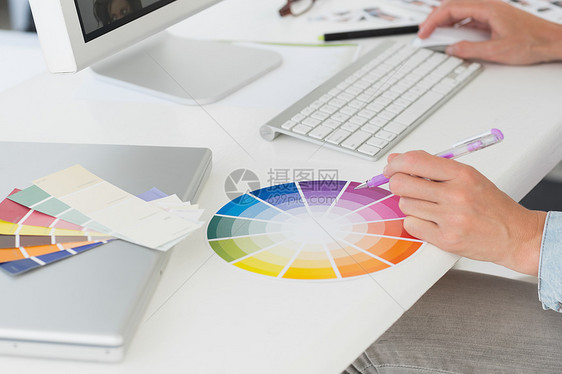 使用彩色轮子在她办公桌工作的设计师图片