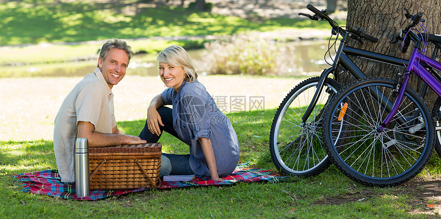 公园里有野餐篮子的夫妇烧瓶时间成人女性闲暇便服亲热绿地夫妻空闲图片