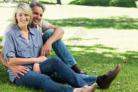 快乐的一对夫妇坐在公园里便服时间闲暇夫妻微笑男人成人农村绿地土地图片