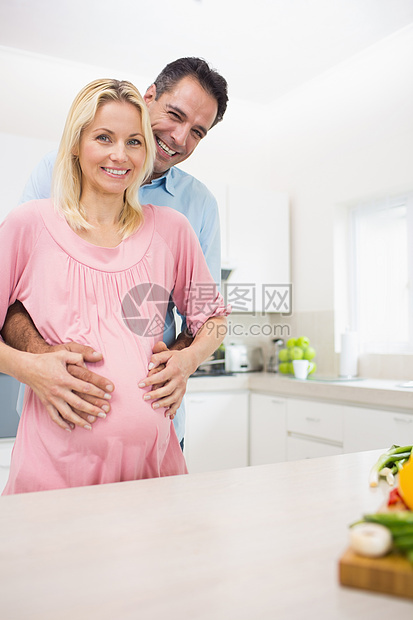 一位在厨房有怀孕母亲的快乐父亲的肖像孕产女性肚子待产夫妻生活男人腹部微笑公寓图片