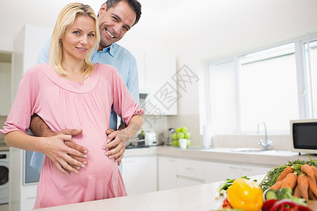 一位在厨房有怀孕母亲的快乐父亲的肖像女性等待公寓肚子家庭育儿待产男人夫妻男性图片