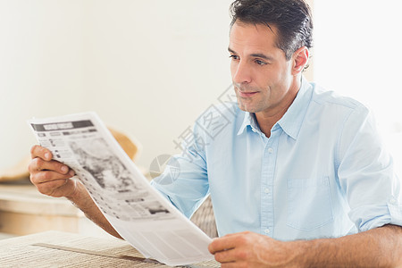 厨房阅读报纸的重度临时男子背景图片