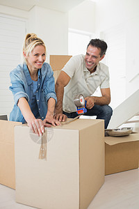 新房里微笑的情侣包装盒闲暇男人胶带纸板磁带搬迁房地产公寓女士女性图片