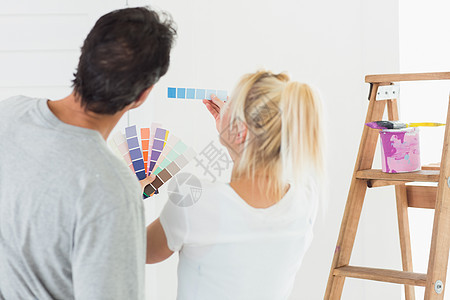 一对夫妇选择房间绘画颜色的近视图图片
